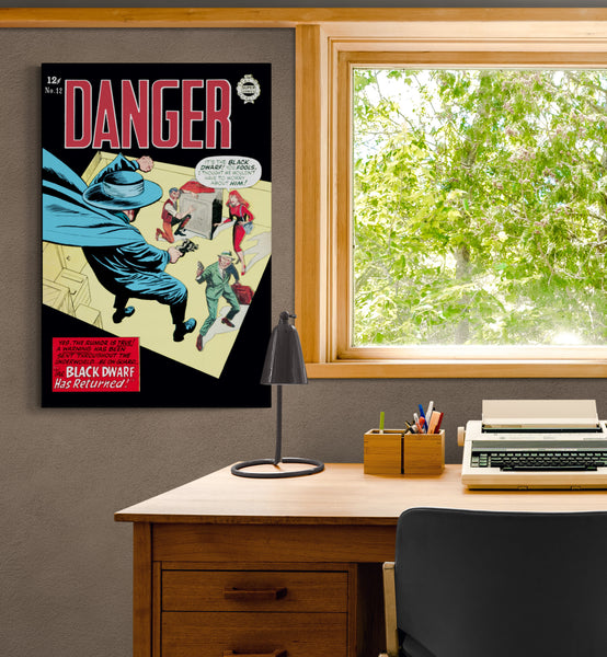 A large matte paper poster of the cover of the 1964 comic book "Danger #12" hung on a beige wall next to a wooden desk with a Brother Correctronic 320 model electronic typewriter.