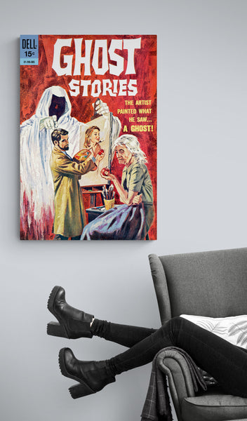 A large matte paper poster of the cover of the 1963 comic book "Ghost Stories #4" hung on a grey wall above a grey couch on which the legs of a lounging woman in skinny jeans and high heel boots are visible