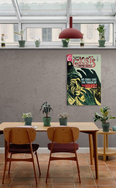 A large matte paper poster of the cover of the 1968 comic book "The Many Ghosts of Doctor Graves" in the lunch room of a modern office containing a table, some chairs, and many small plants