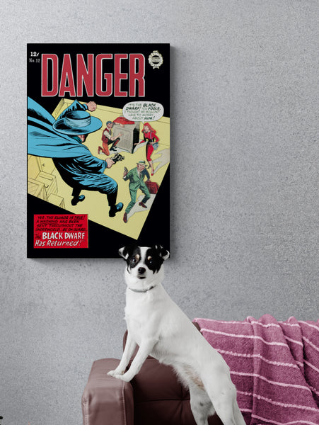 A large matte paper poster of the cover of the 1964 comic book "Danger #12" hung on a concrete wall next to a pleather couch with a Jack Russel Terrier standing on it