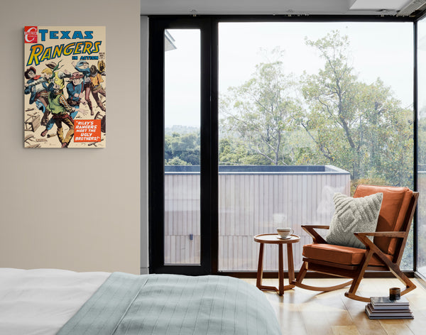 A large matte paper poster of the cover of the 1954 comic book "Texas Rangers #63" hung next to a floor-to-ceiling window in a cozy bedroom containing a rocking chair with some books and tea