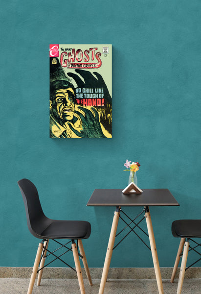 A large matte paper poster of the cover of the 1968 comic book "The Many Ghosts of Doctor Graves" in a bistro hanging  on a greenish blue wall above a dining table with two chairs